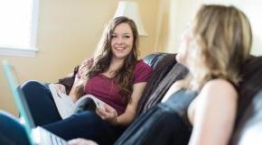 Two students talking on couch in residence hall